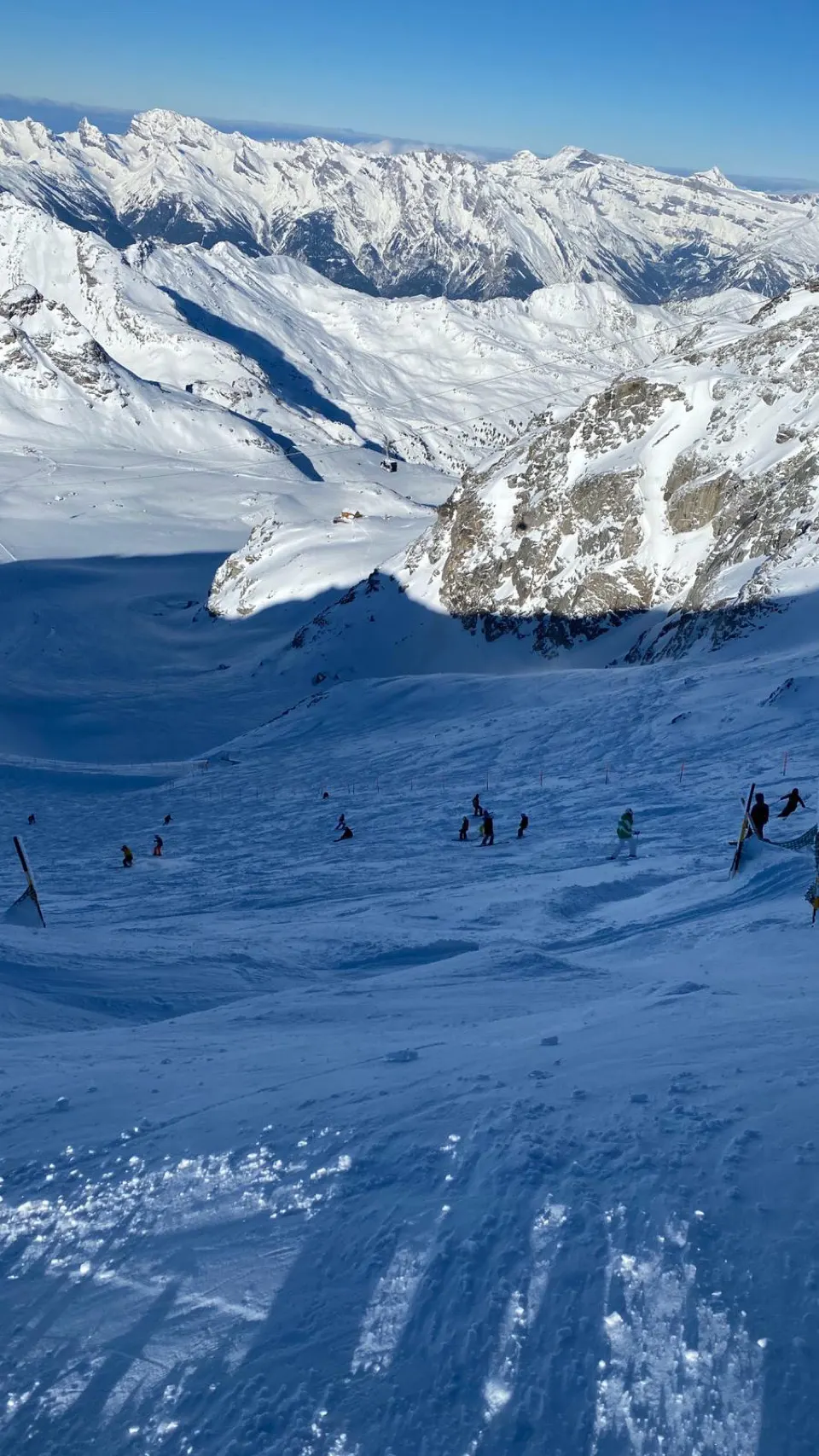 Brede besneeuwde piste boven Verbier onder een strakblauwe lucht