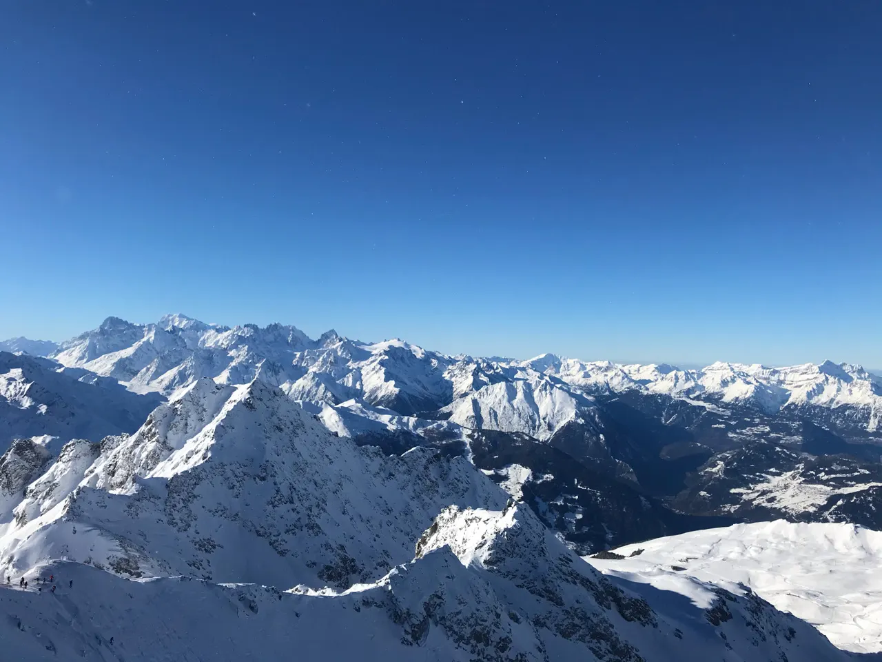 Panorama van besneeuwde Alpentoppen onder een strakblauwe lucht bij Verbier